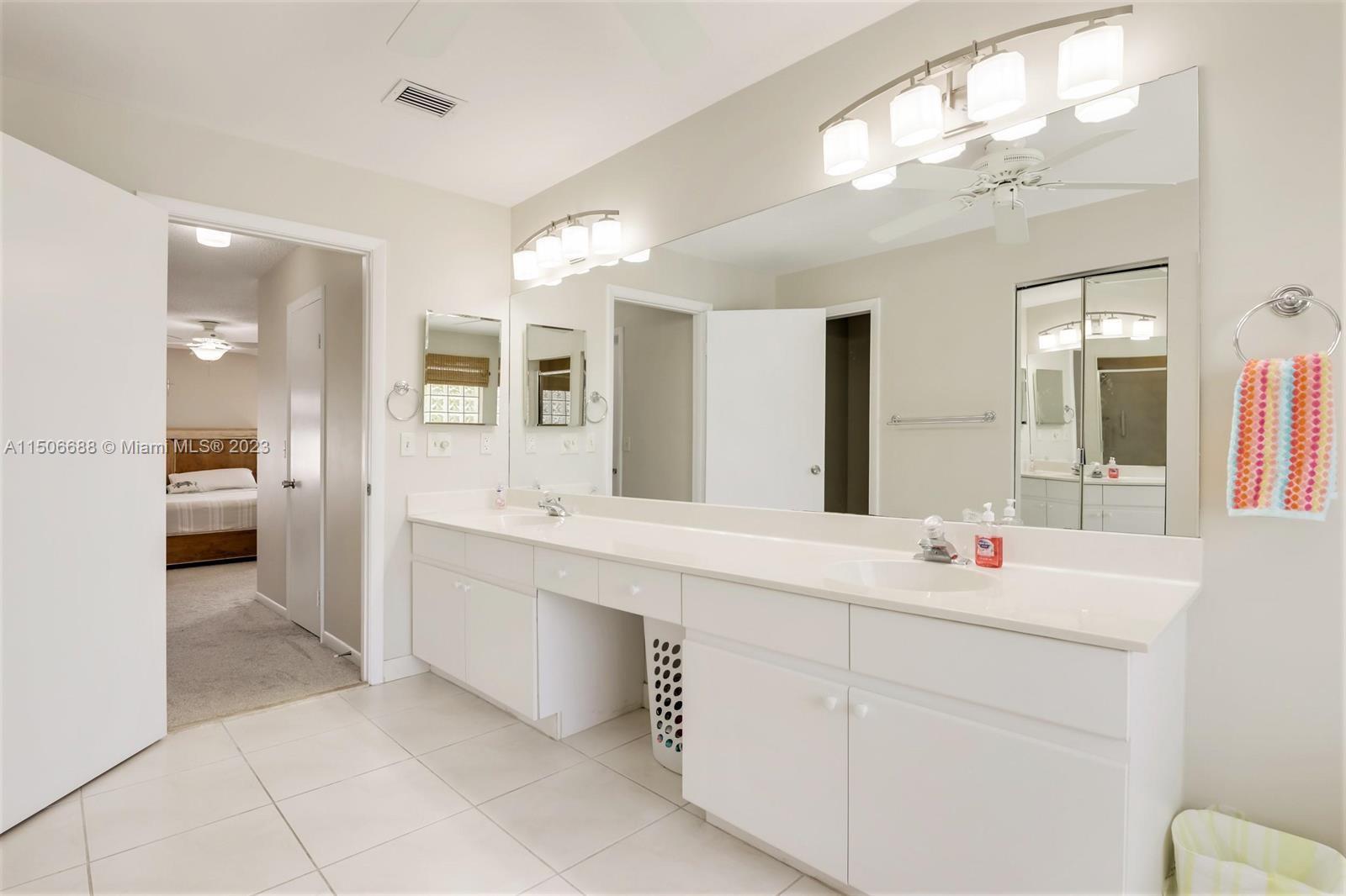 7289 Shell Ridge Terrace Lake Worth, FL 33467 - Photo 33 of 55 a en suite bathroom with a double vanity sink a mirror and a toilet