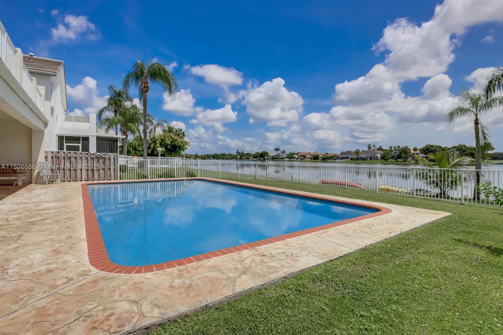7289 Shell Ridge Terrace Lake Worth, FL 33467 - Photo 46 of 55 a view of a swimming pool and lake in the background