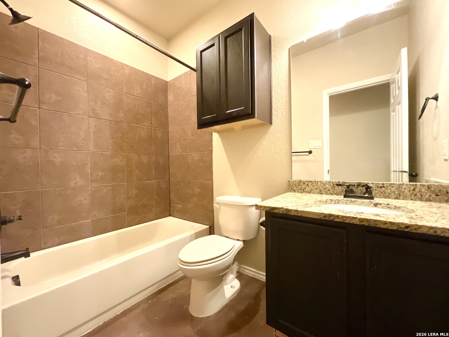 2575 Pahmeyer Road New Braunfels, TX 78130 - Photo 16 of 31 a bathroom with a granite countertop sink toilet a mirror and bathtub
