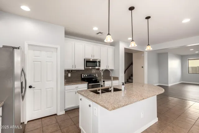a kitchen with a refrigerator a sink and a microwave