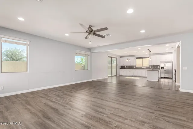 a view of an empty room with window and wooden floor