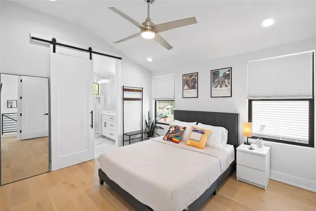 a bedroom with a large bed and a chandelier