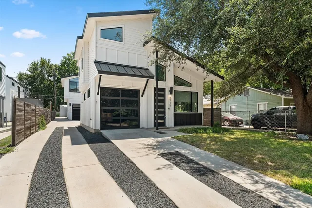 a view of a house with a yard and large tree