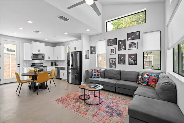 a living room with furniture kitchen view and a window