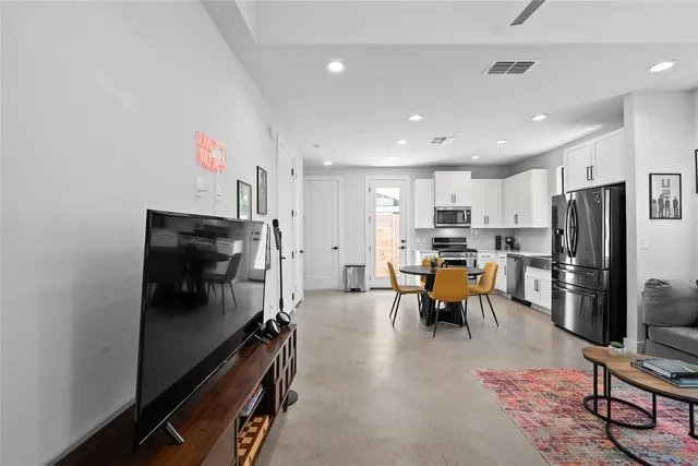 a kitchen with stainless steel appliances refrigerator microwave and dining table