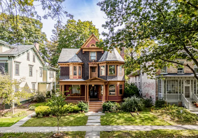 a front view of a residential apartment building with a yard and potted plants