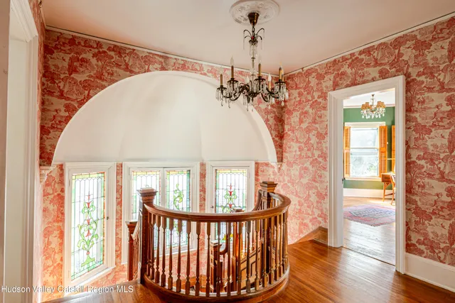 a view of a hallway with wooden floor and a potted plant