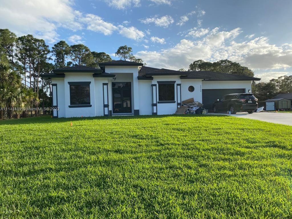 a view of a house with a yard and potted plants
