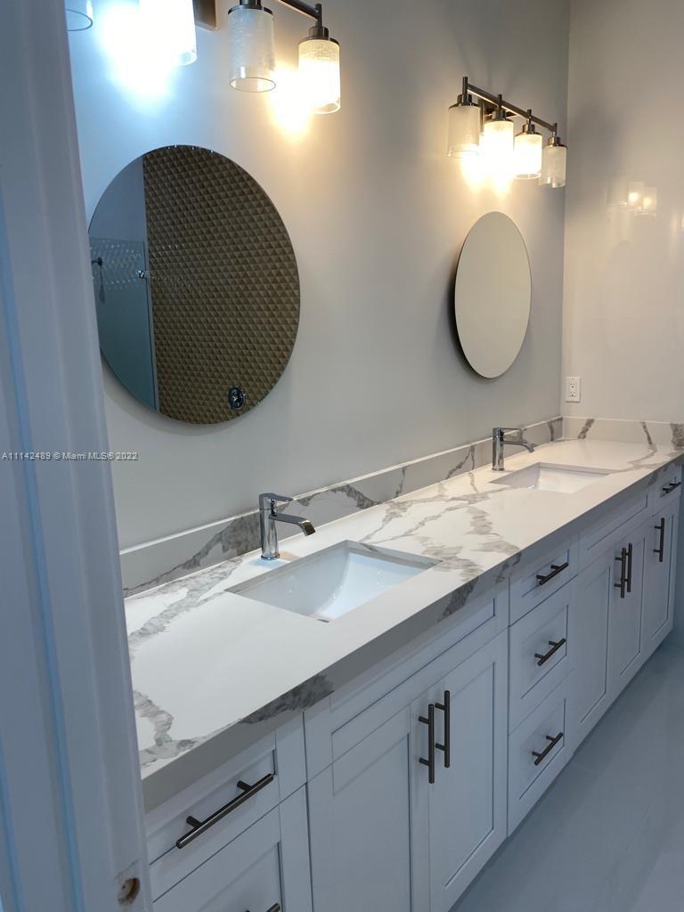 17566 93rd Road North Loxahatchee, FL 33470 - Photo 4 of 6 a bathroom with a double vanity sink and a mirror