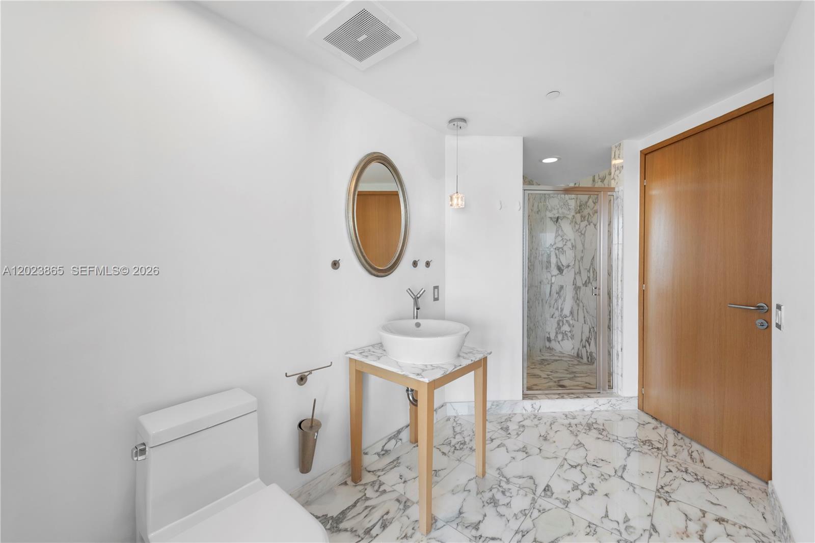 450 Alton Road, Unit 3206 Miami Beach, FL 33139 - Photo 17 of 25 a bathroom with a sink a toilet and a mirror