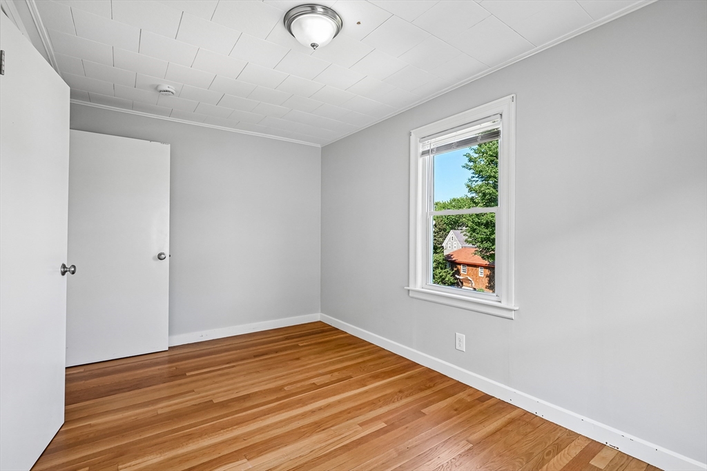 42 East Main Street Gloucester, MA 01930 - Photo 6 of 25 a view of an empty room with wooden floor and a window