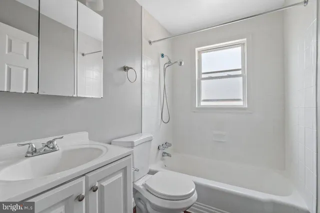 a bathroom with a sink toilet vanity and shower