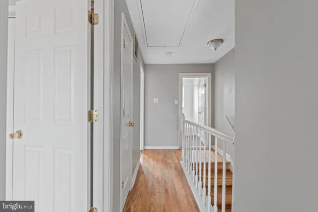 a view of a hallway with wooden floor and entryway