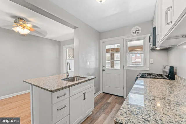 a kitchen with granite countertop a sink and a stove top oven