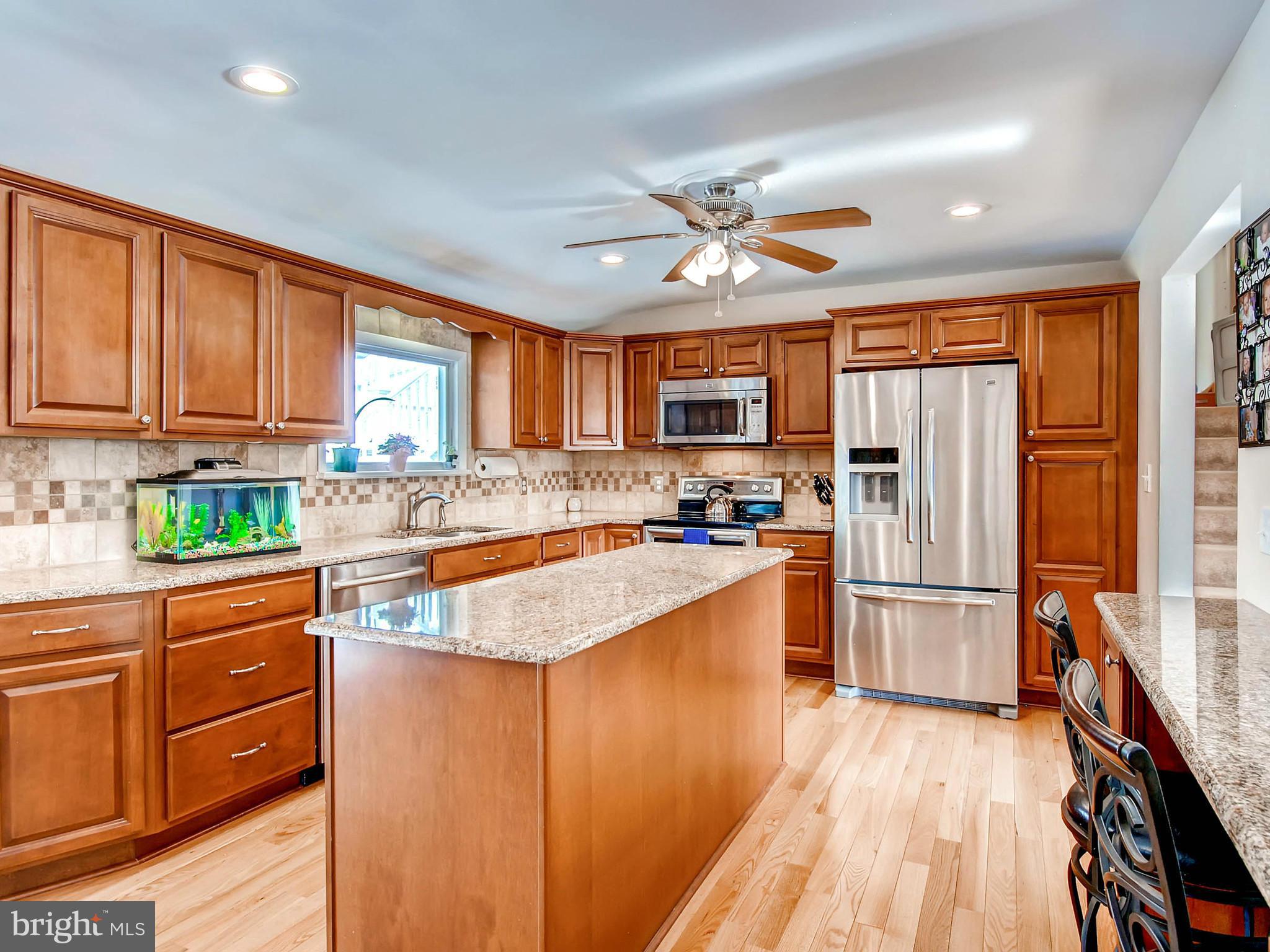 2607 Fallston Road Fallston, MD 21047 - Photo 9 of 30 a kitchen with stainless steel appliances granite countertop a refrigerator a stove top oven a sink dishwasher and wooden cabinets