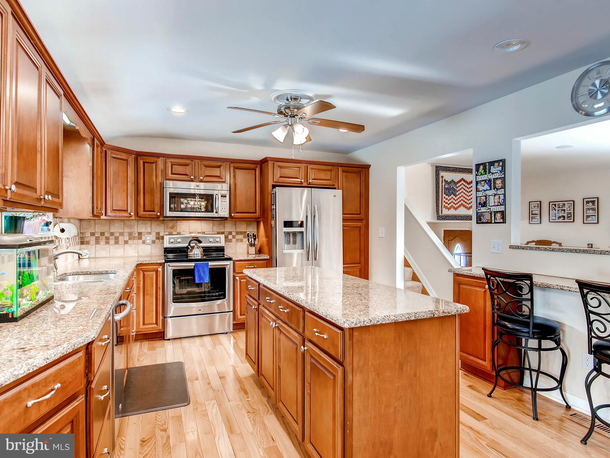 2607 Fallston Road Fallston, MD 21047 - Photo 10 of 30 a kitchen with stainless steel appliances granite countertop a refrigerator a stove top oven a sink dishwasher and white cabinets with wooden floor
