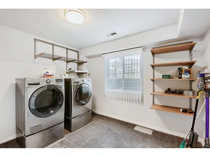 a utility room with dryer washer and a view of kitchen