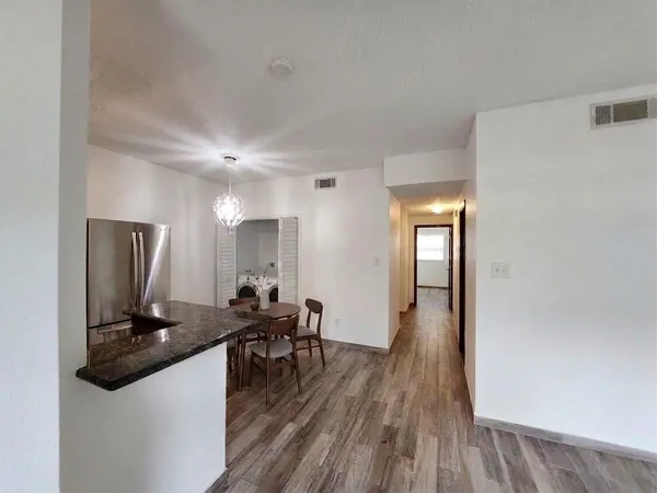 a view of a hallway with wooden floor and furniture