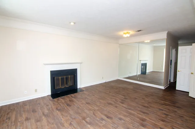 a view of empty room with wooden floor and fireplace