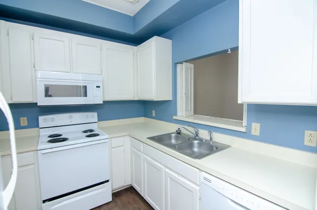 a kitchen with cabinets appliances a sink and a counter top