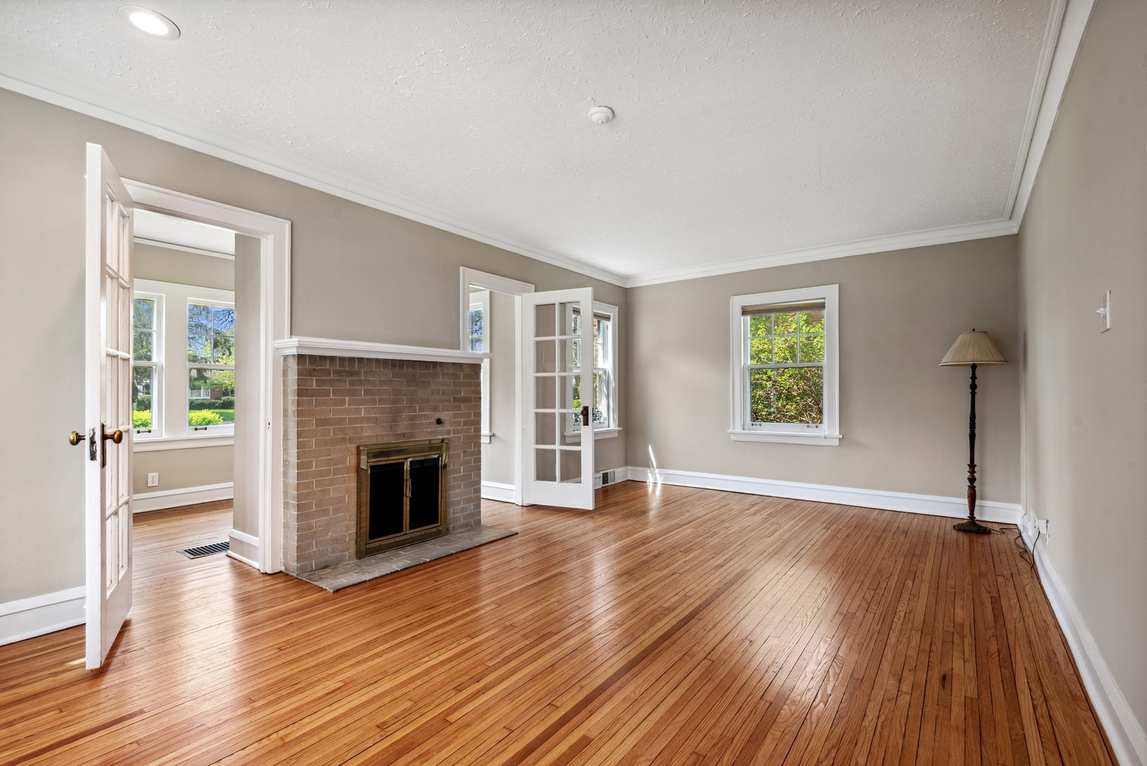 1130 Ridge Road Wilmette, IL 60091 - Photo 4 of 16 an empty room with wooden floor a fireplace and windows
