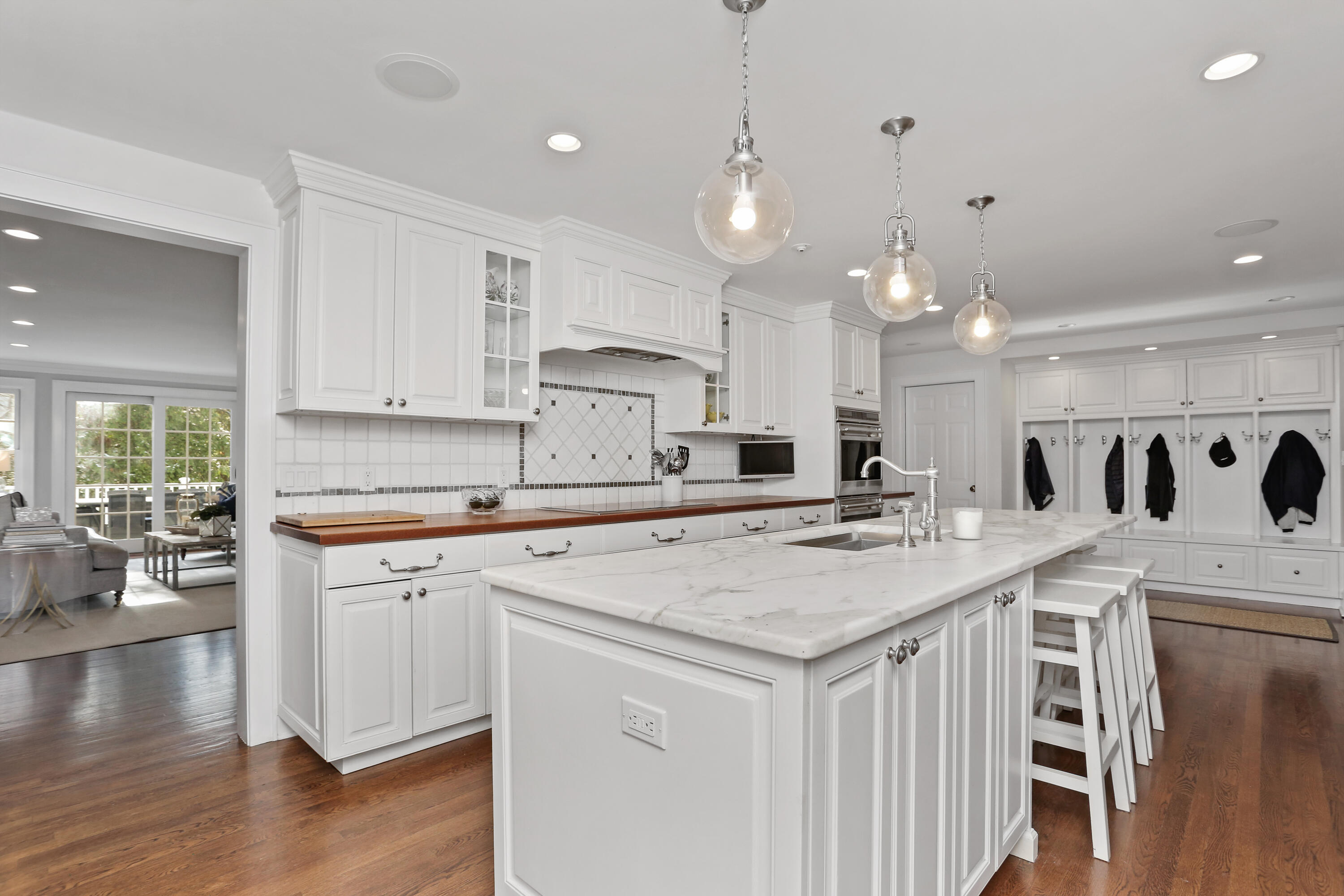 8 Beach Drive Darien, CT 06820 - Photo 10 of 27 a kitchen with stainless steel appliances granite countertop a stove a sink a kitchen island with white cabinets and wooden floor