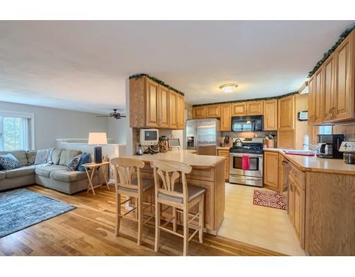 37 Governor Fuller Road Billerica, MA 01821 - Photo 8 of 27 a kitchen with stainless steel appliances kitchen island granite countertop a refrigerator a stove a sink dishwasher and white cabinets with wooden floor
