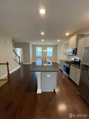 a kitchen with stainless steel appliances granite countertop a sink a stove top oven a counter space and cabinets