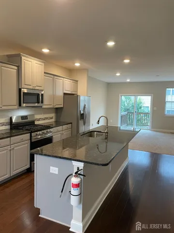 a kitchen with stainless steel appliances granite countertop a sink a stove and a microwave