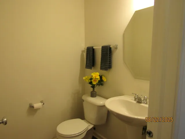 a bathroom with a sink and mirror with toilet