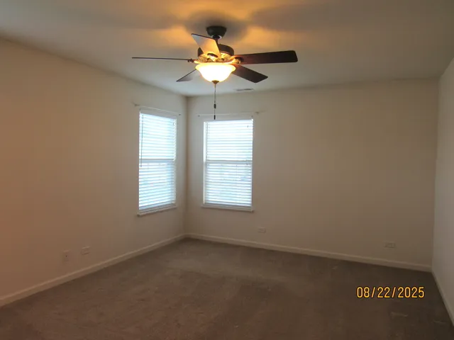 an empty room with a window and a fan