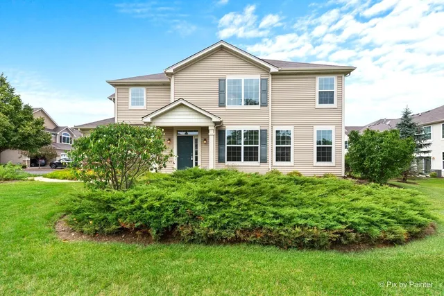 a front view of a house with a yard and trees