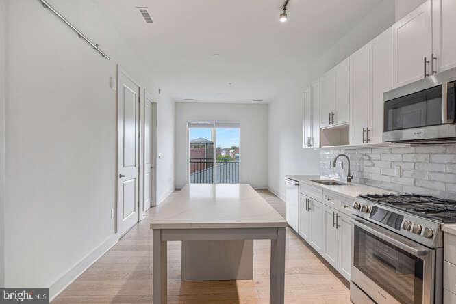 6803 Cameron Drive Northwest, Unit 314 Washington, DC 20012 - Photo 15 of 25 a kitchen with stainless steel appliances a stove microwave and sink