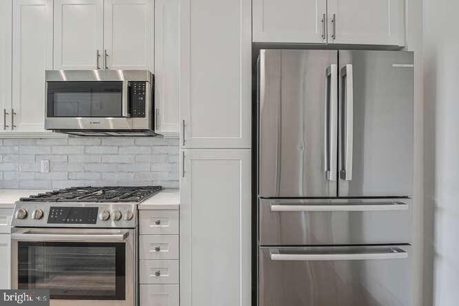 6803 Cameron Drive Northwest, Unit 314 Washington, DC 20012 - Photo 16 of 25 a kitchen with cabinets and stainless steel appliances