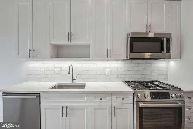 6803 Cameron Drive Northwest, Unit 314 Washington, DC 20012 - Photo 17 of 25 a kitchen with granite countertop a stove and a sink