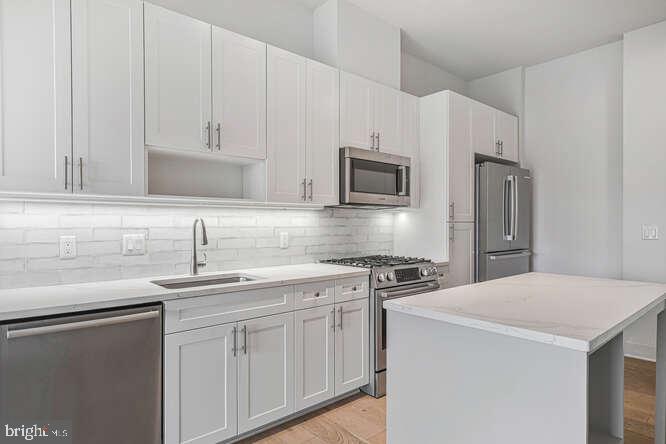 6803 Cameron Drive Northwest, Unit 314 Washington, DC 20012 - Photo 18 of 25 a kitchen with appliances a sink and cabinets
