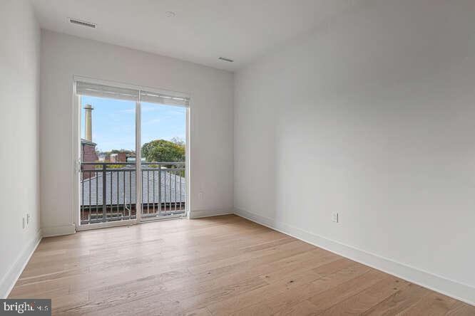 6803 Cameron Drive Northwest, Unit 314 Washington, DC 20012 - Photo 22 of 25 an empty room with wooden floor and windows
