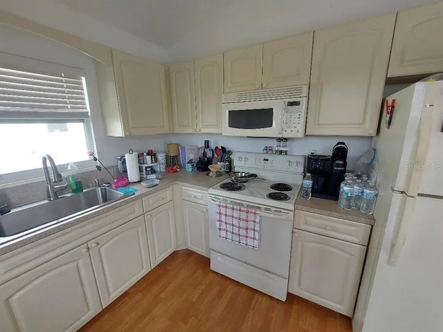 a kitchen with stainless steel appliances white cabinets a sink and a refrigerator
