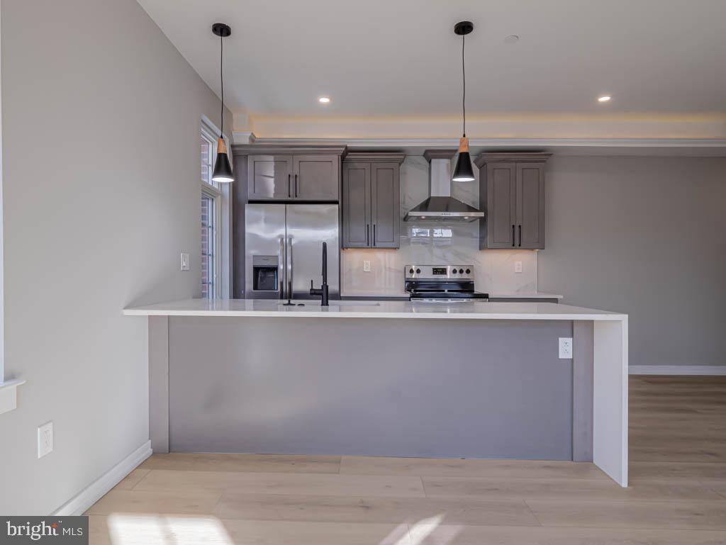a kitchen with stainless steel appliances granite countertop a sink a stove and a wooden floors