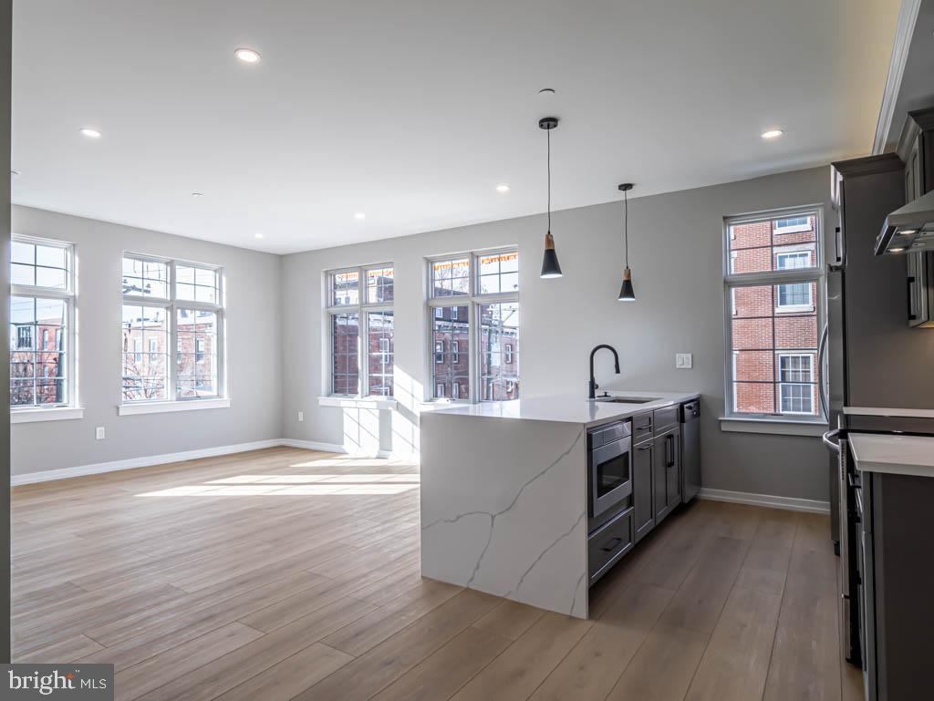 769 South 10th Street, Unit 3D Philadelphia, PA 19147 - Photo 3 of 9 a large kitchen with stainless steel appliances granite countertop a lot of counter space and wooden floors
