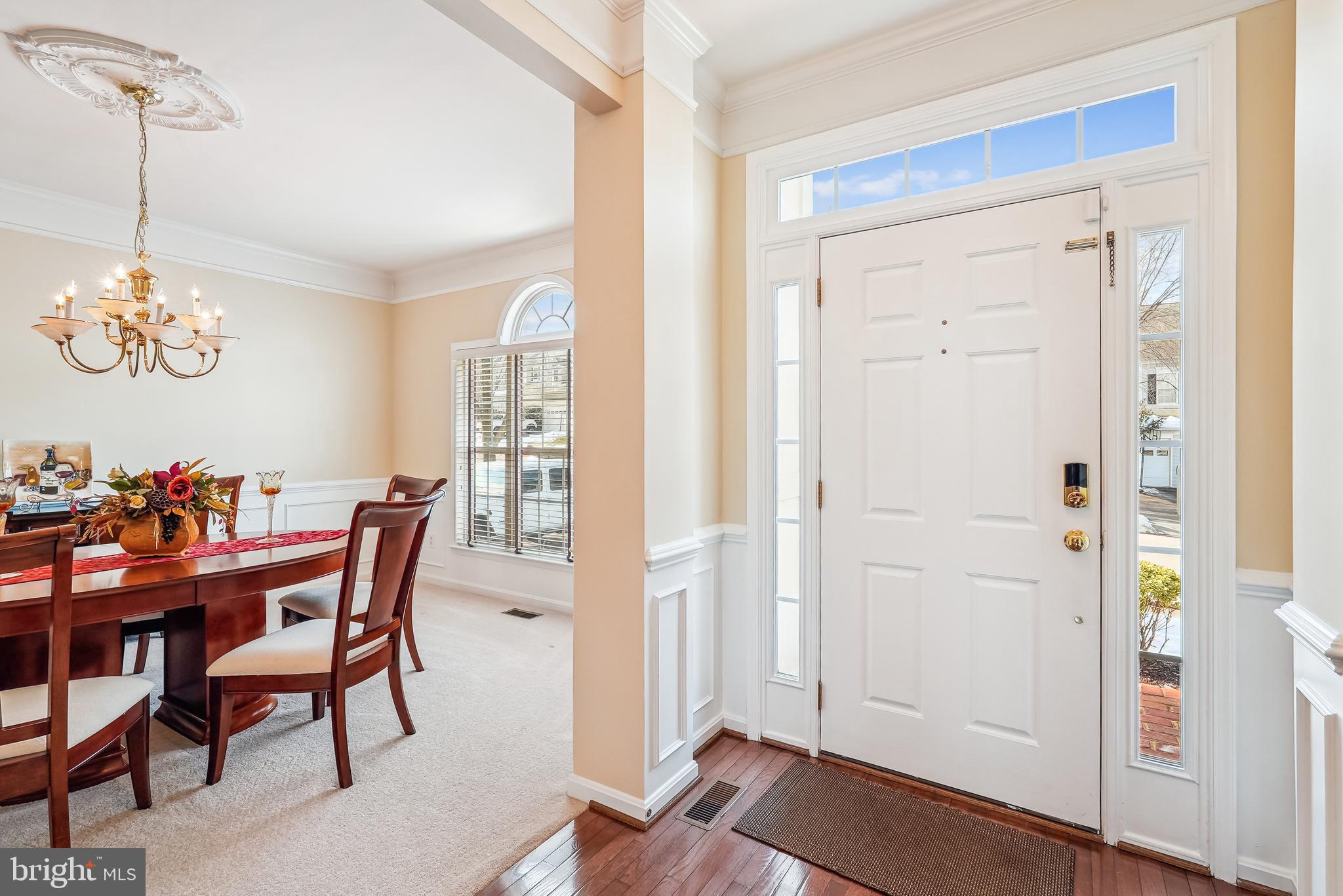 42801 Ridgeway Drive Broadlands, VA 20148 - Photo 3 of 40 a dining room with furniture wooden floor a rug and a chandelier