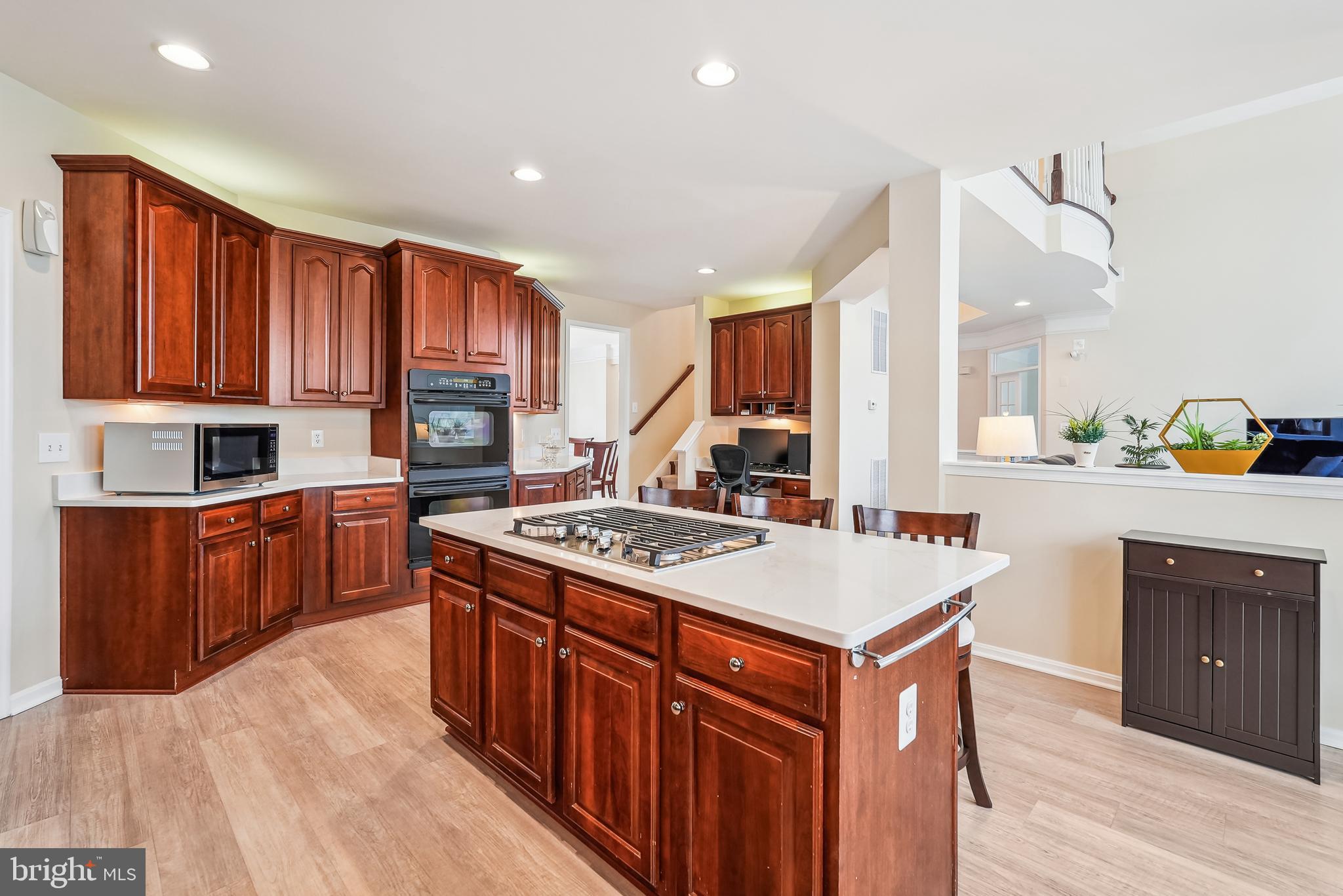 42801 Ridgeway Drive Broadlands, VA 20148 - Photo 9 of 40 a kitchen with stainless steel appliances granite countertop a stove a sink dishwasher and a refrigerator with wooden cabinets
