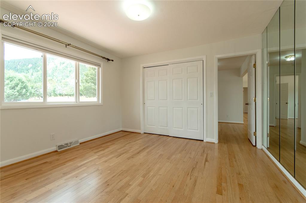 4710 Limestone Road Monument, CO 80132 - Photo 16 of 50 a view of an empty room with wooden floor and a window