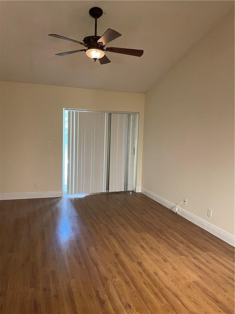5686 Rock Island Road, Unit 130 Tamarac, FL 33319 - Photo 3 of 23 a view of an empty room with a window and wooden floor
