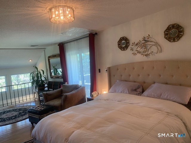 200 Brittany Farms Road, Unit D New Britain, CT 06053 - Photo 18 of 36 a bedroom with a bed and a chandelier