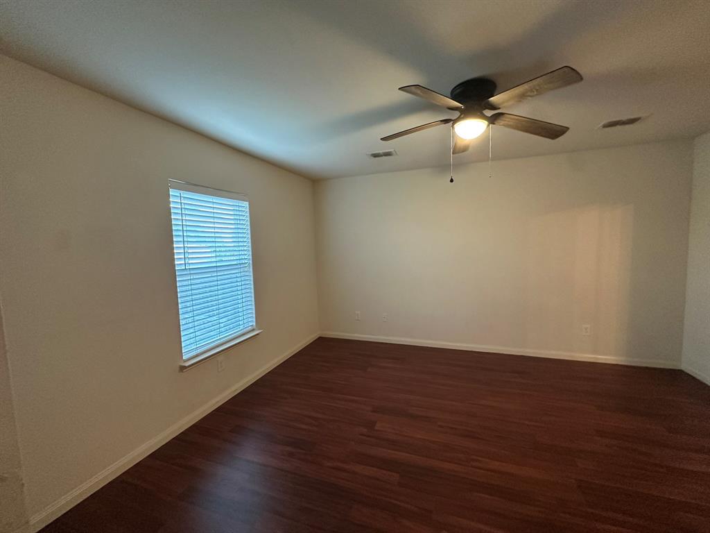 1818 Clegg Street Howe, TX 75459 - Photo 13 of 34 Spacious interior room featuring rich wood-finish flooring, a white ceiling fan with integrated lighting, and a window with blinds