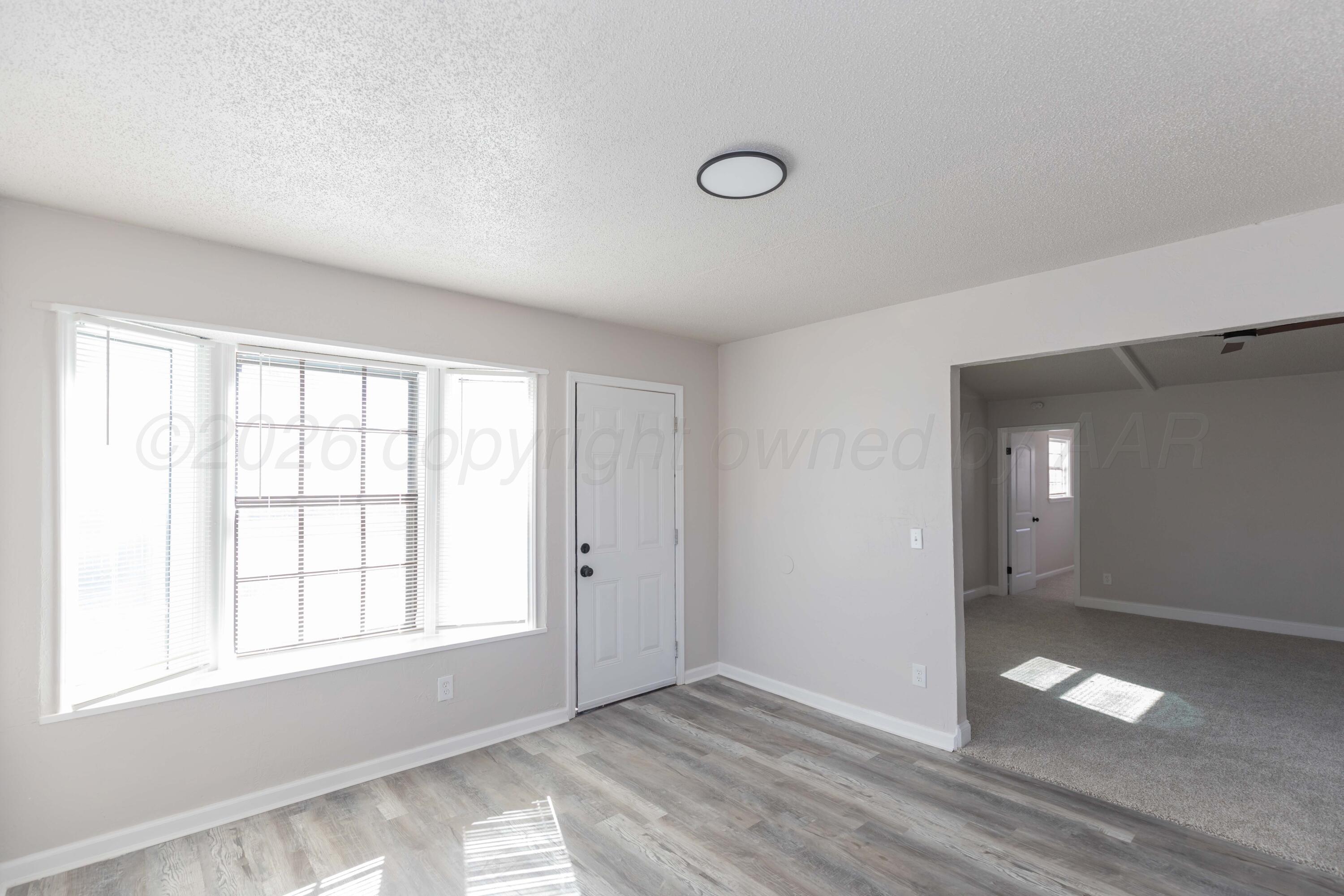 2915 Hodges Street Amarillo, TX 79103 - Photo 14 of 34 an empty room with wooden floor and windows