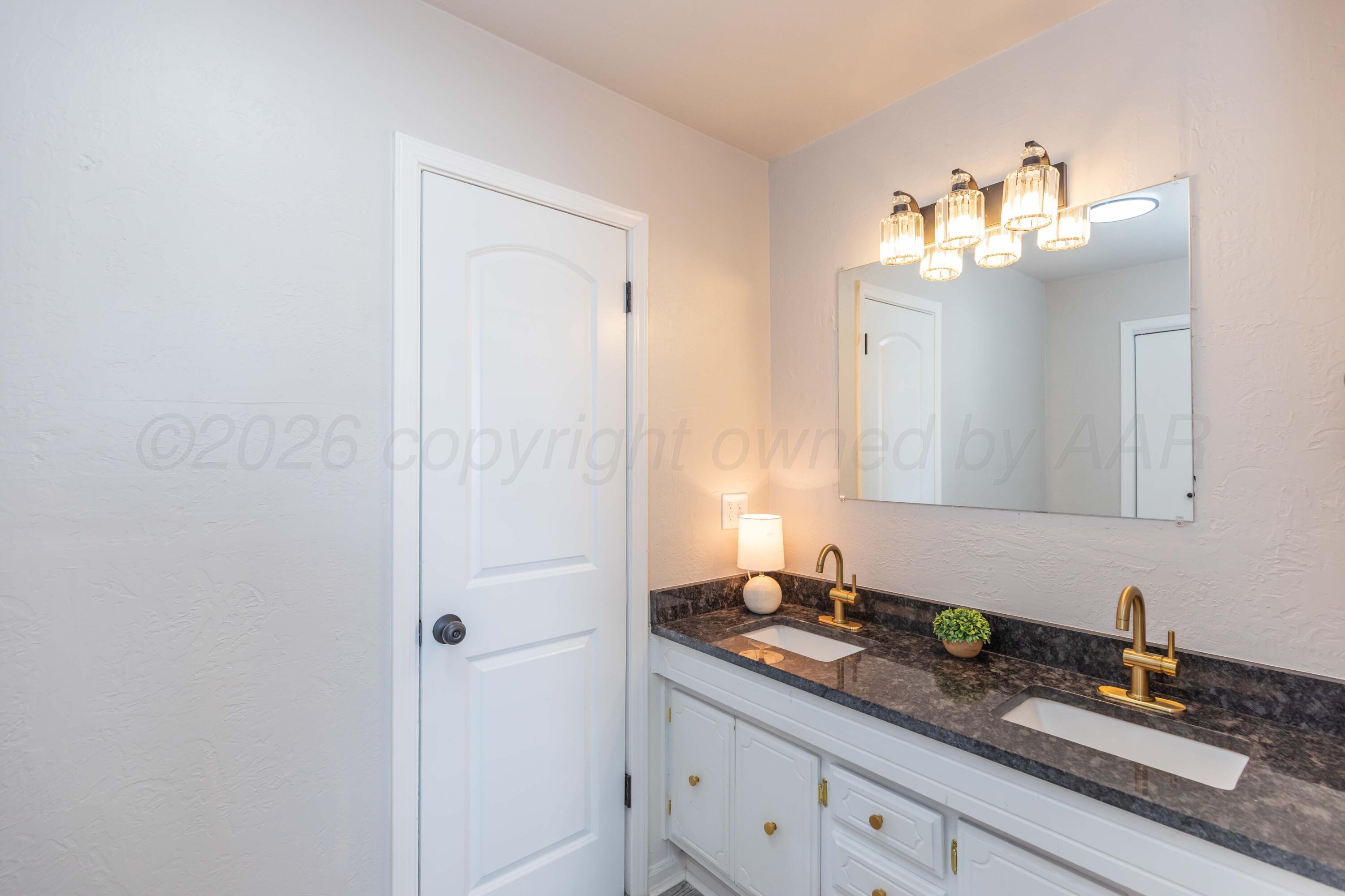 2915 Hodges Street Amarillo, TX 79103 - Photo 22 of 34 a bathroom with a sink and a mirror