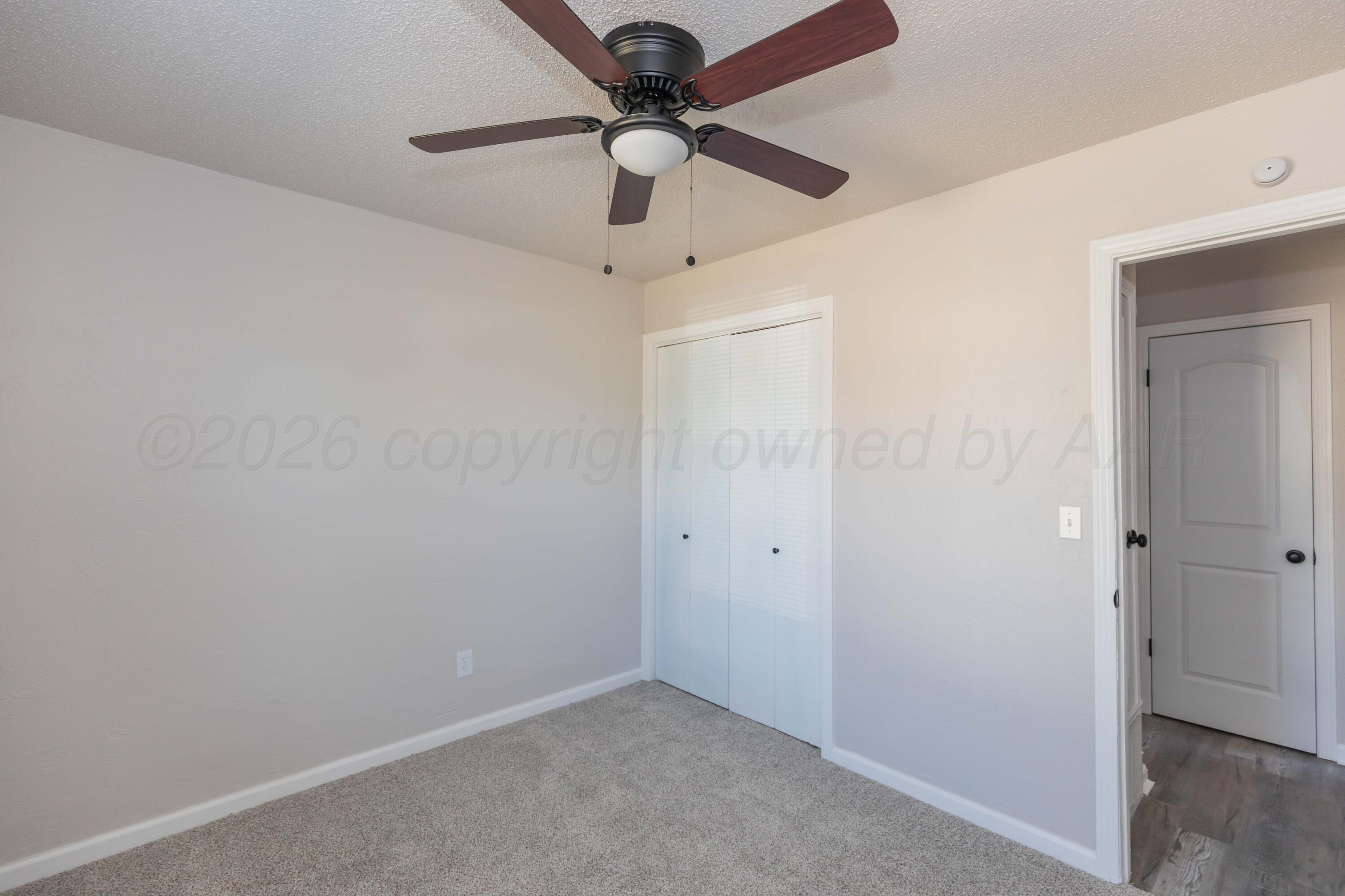 2915 Hodges Street Amarillo, TX 79103 - Photo 25 of 34 an empty room with a ceiling fan and carpet