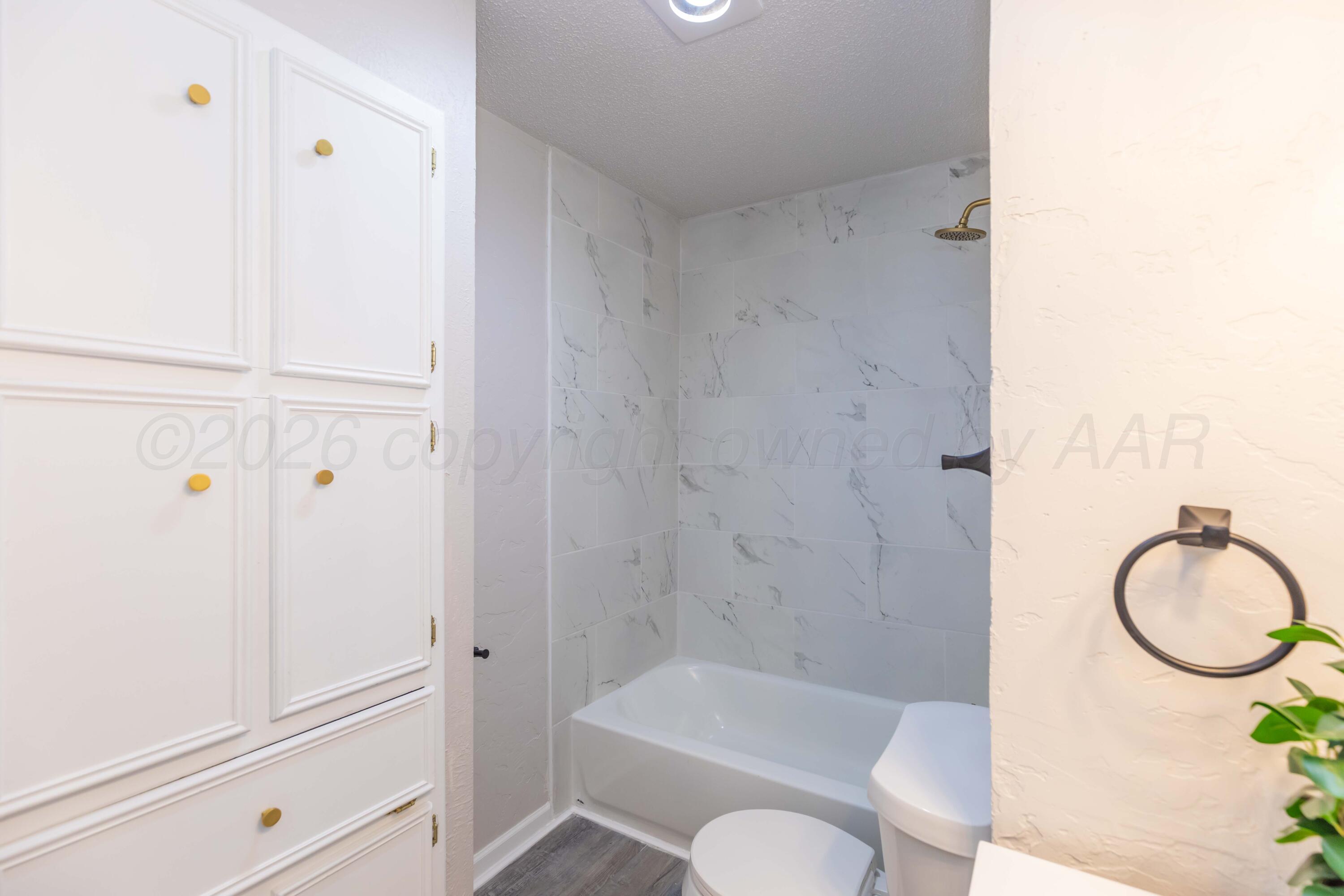 2915 Hodges Street Amarillo, TX 79103 - Photo 28 of 34 a bathroom with a granite countertop bathtub shower sink vanity and toilet